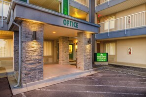 A hotel entrance with a stone facade, an 'Office' sign, and a 'Home Towne Studios' sign. - HomeTowne Studios By Red Roof Denver - Airport/ Aurora (Aurora)