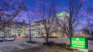 A hotel entrance with a sign for HomeTowne Studios & RedRoof. - HomeTowne Studios By Red Roof Denver - Airport/ Aurora (Aurora)