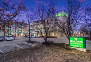 A hotel entrance with a sign for HomeTowne Studios & RedRoof. - HomeTowne Studios By Red Roof Denver - Airport/ Aurora (Aurora)
