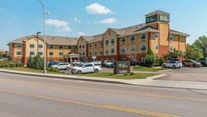 A multi-story hotel with a bike lane sign, parking lot, and clear skies.