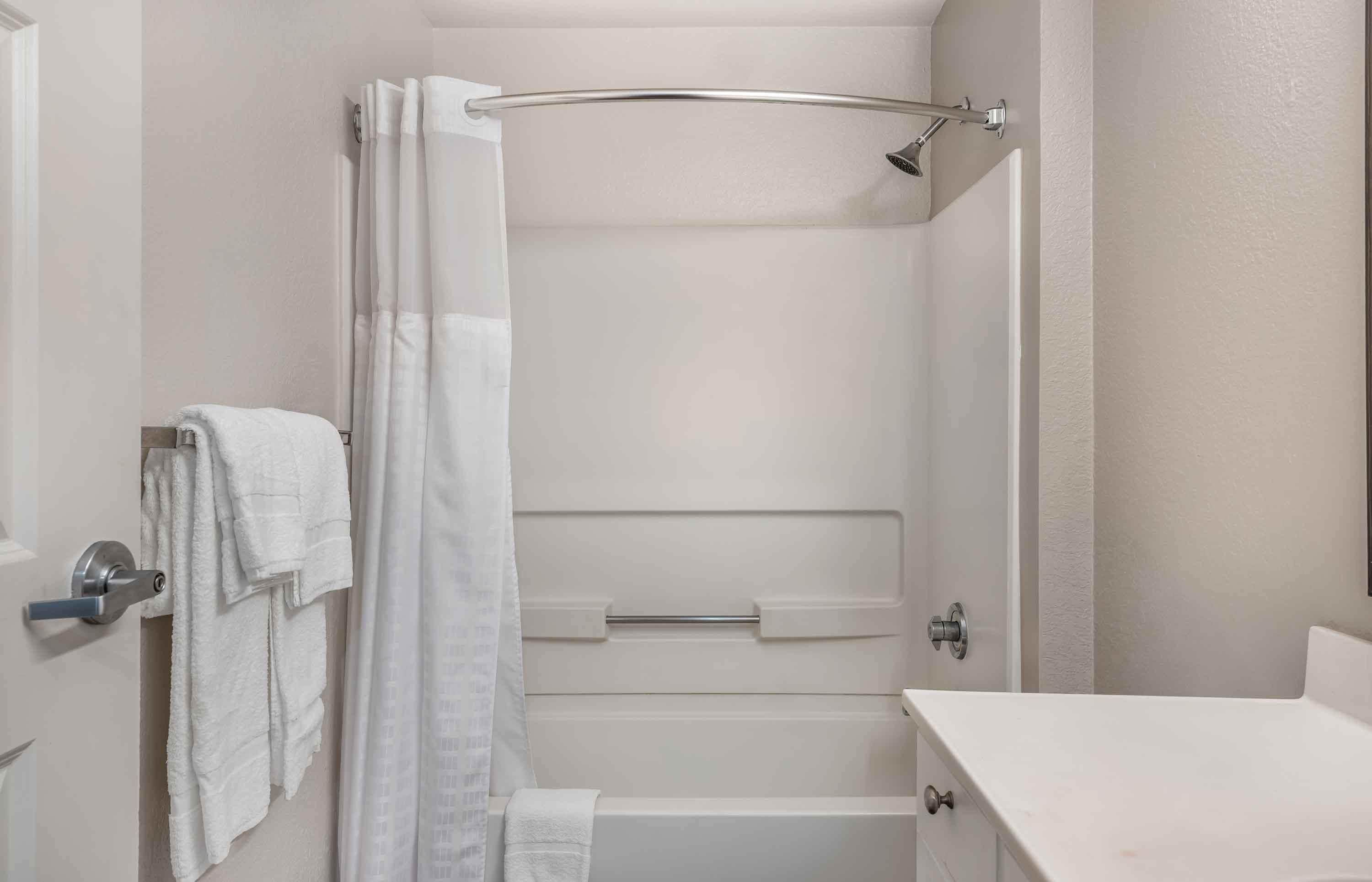 Een badkamer met een douche, een handdoekhouder en een toilet.