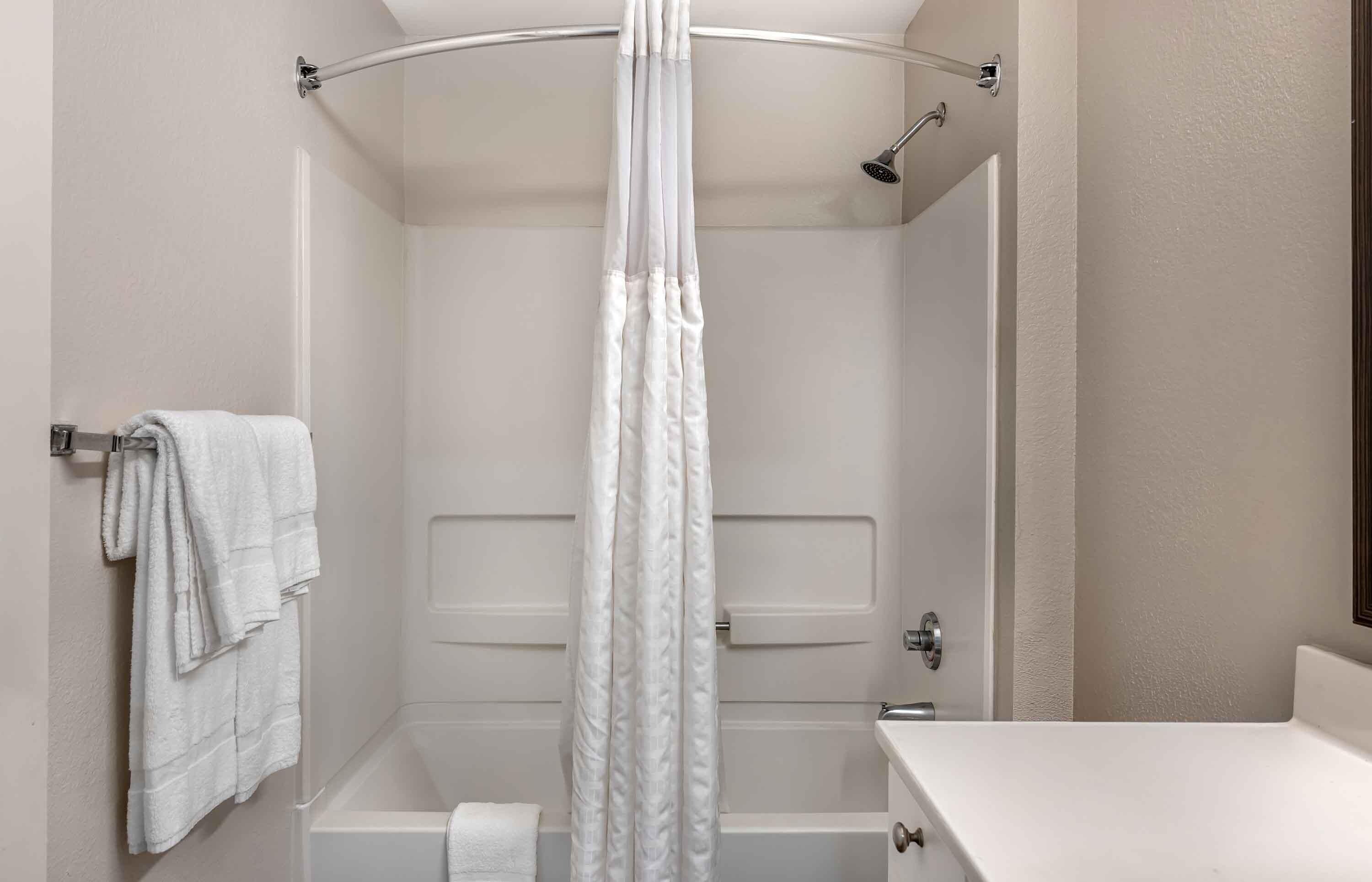 Un baño con bañera, cortina de ducha y un perchero para toallas.