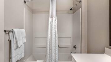 Un baño con bañera, cortina de ducha y un perchero para toallas.