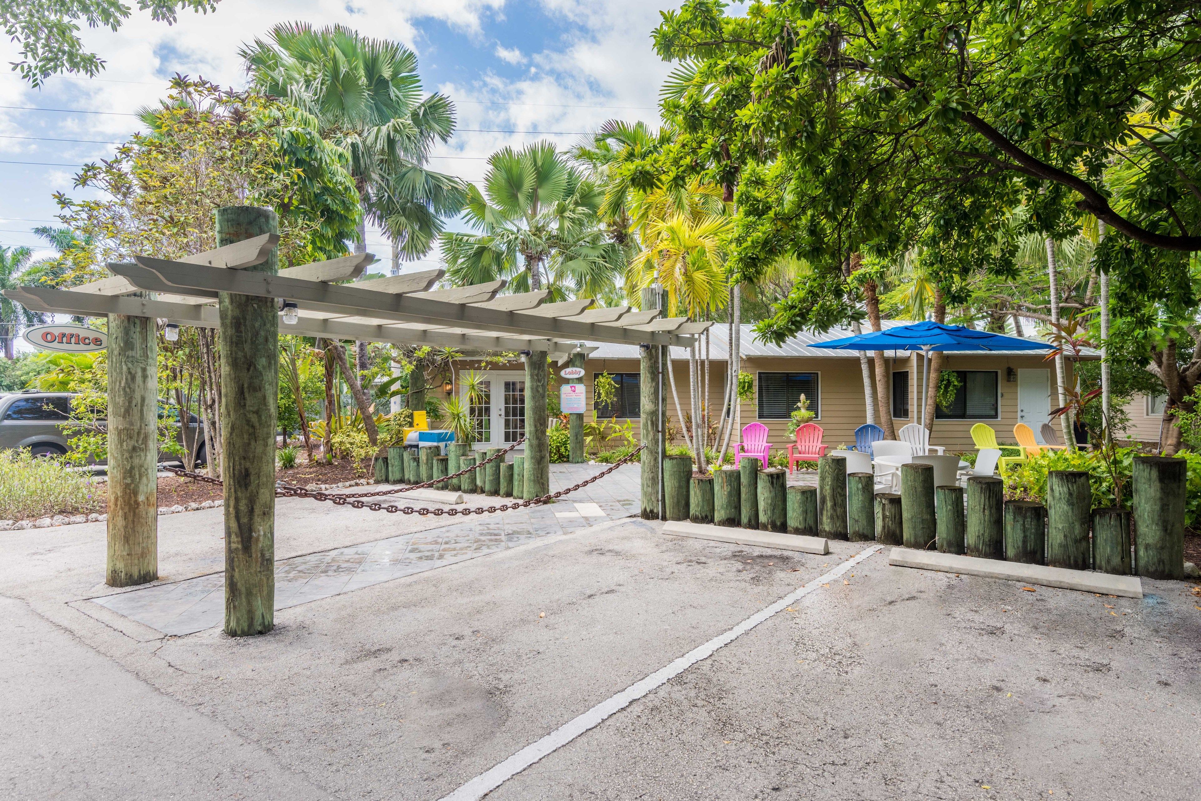 A covered outdoor area with a chain-link fence, wooden posts, and a blue umbrella.