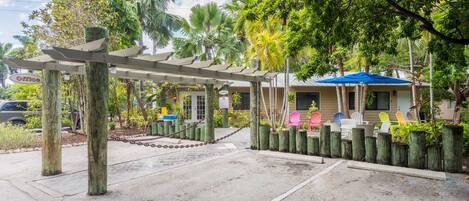 A covered outdoor area with a chain-link fence, wooden posts, and a blue umbrella.