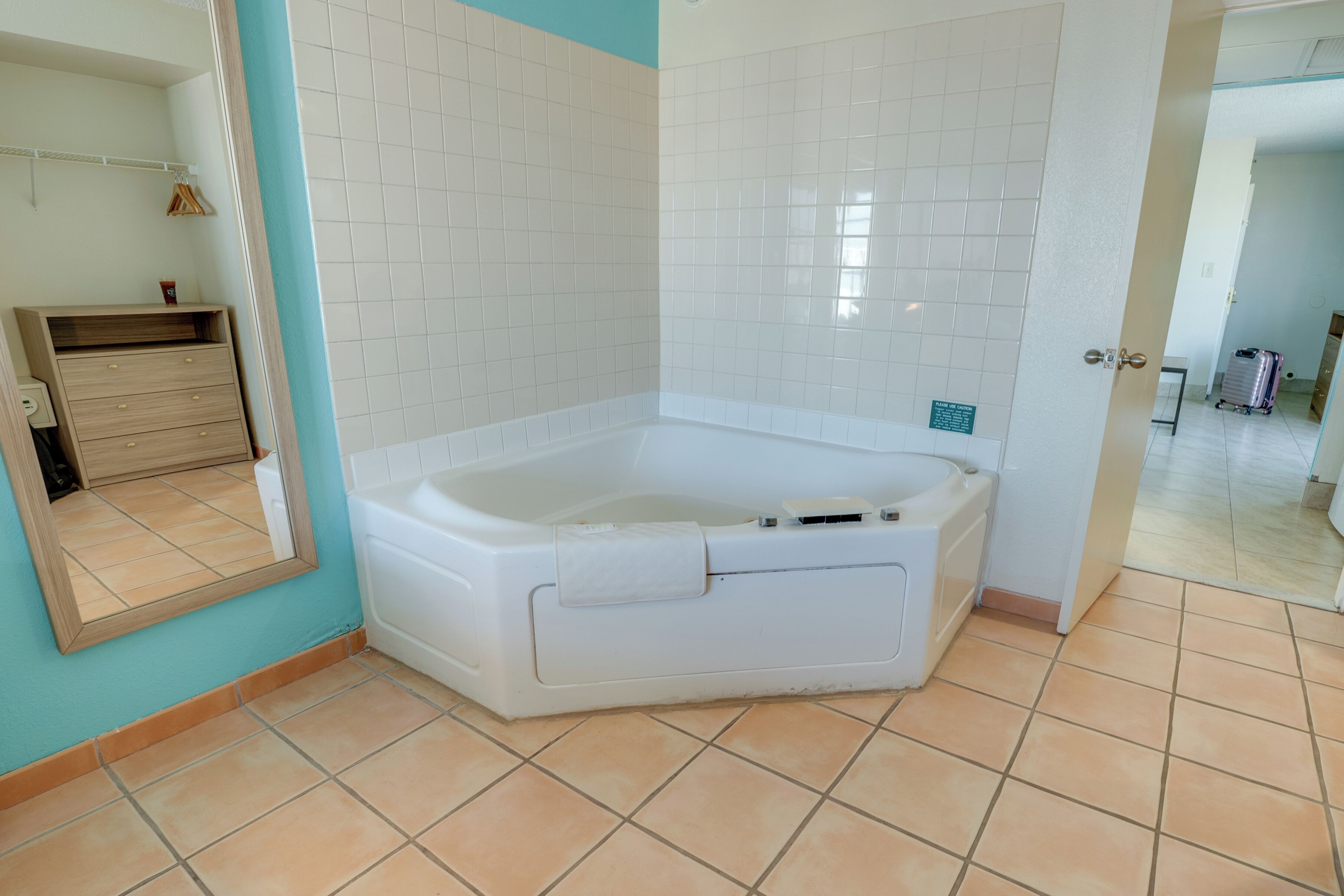 Un baño con una bañera blanca, un tocador de madera y un espejo.
