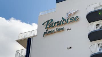 A building with a sign that reads "Paradise Plaza Inn" and a decorative element resembling a sailboat.