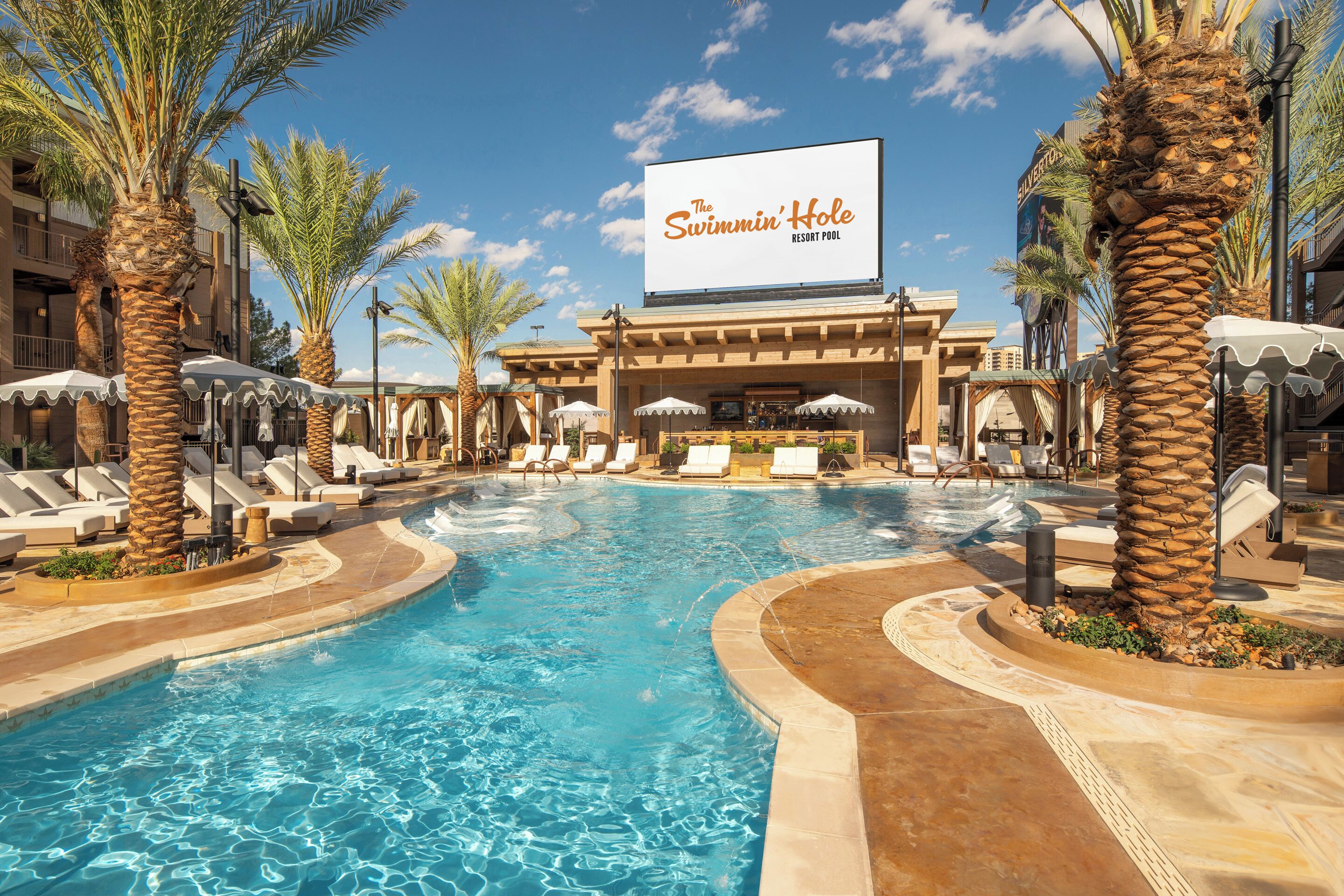 Una piscina al aire libre, camas de piscina gratis, sombrillas