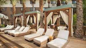 Un espace aménagé au bord de la piscine, avec des chaises longues et des pergolas en bois.