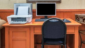 A wooden desk with a computer, monitor, keyboard, and mouse.