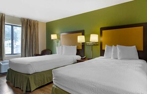 A hotel room with two beds, green walls, and a large window with curtains. - Extended Stay America Suites Houston NASA Johnson Space Ctr (Houston)