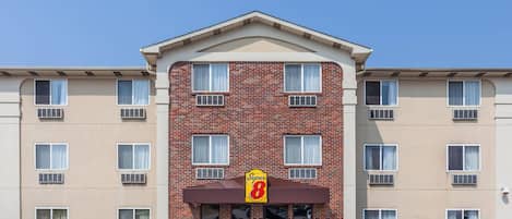 A hotel with a brick facade, multiple windows, and a sign indicating a Super 8 rating.