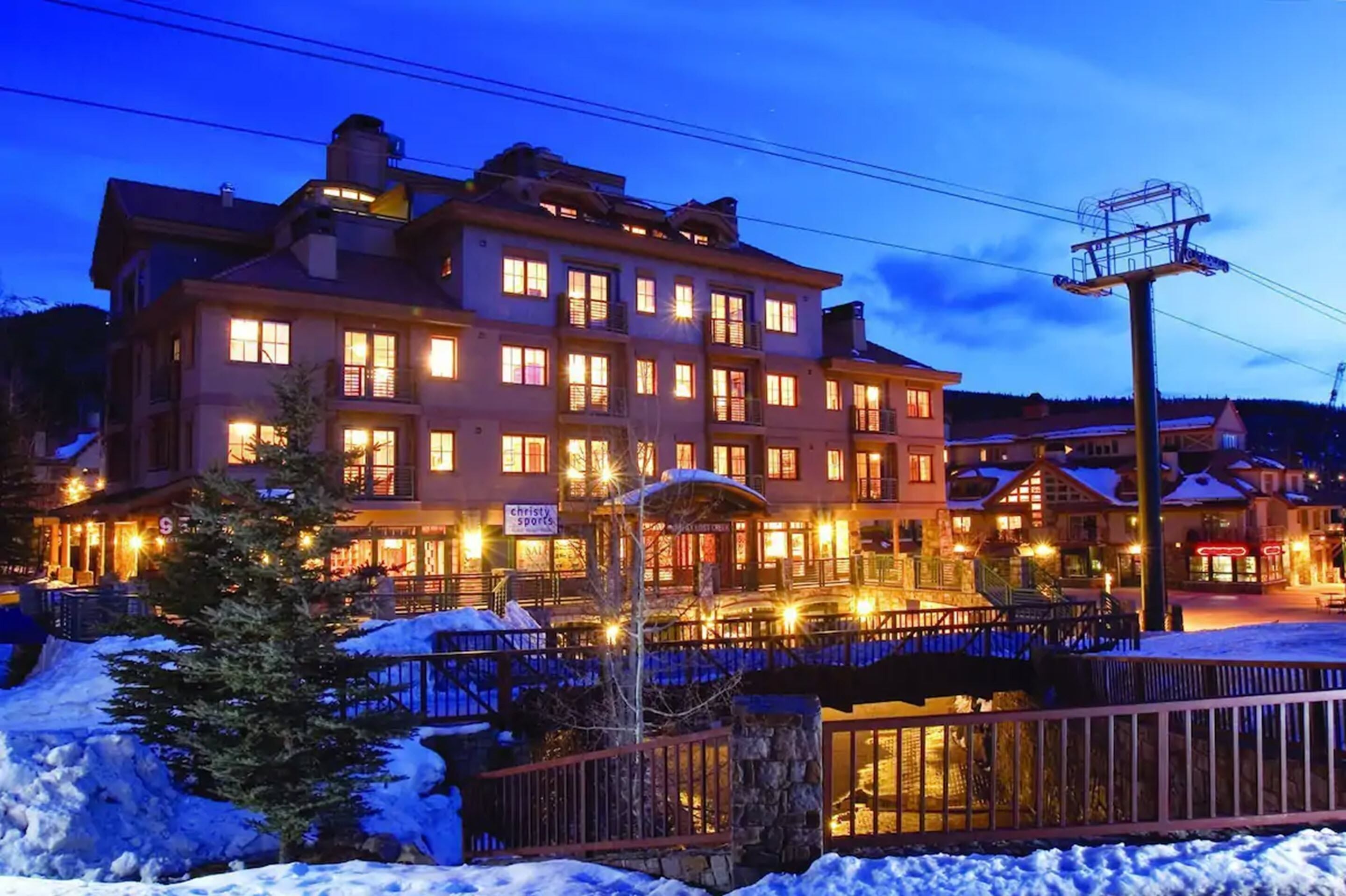 A multi-story hotel with illuminated windows and a snow-covered ground.