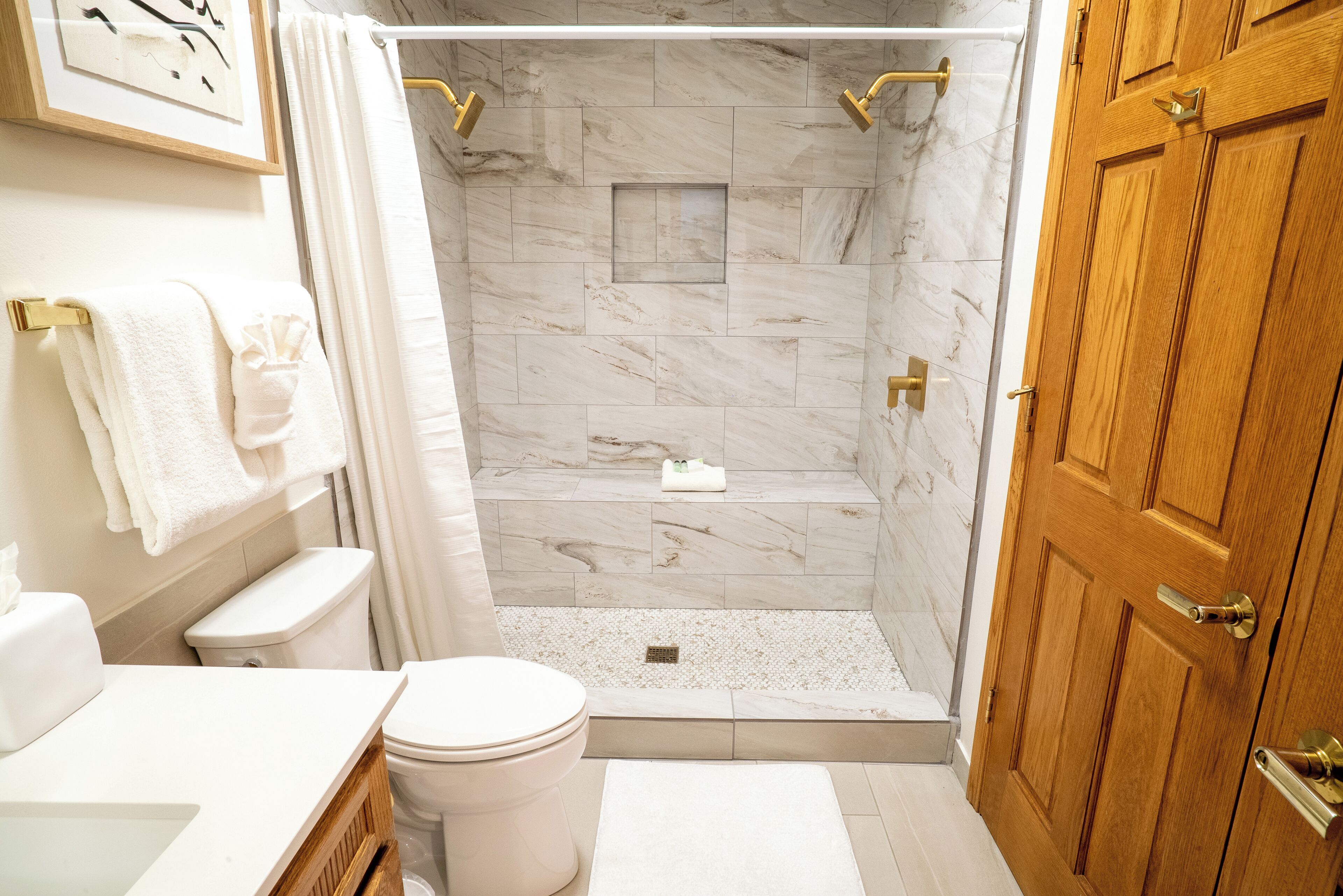 A bathroom with a shower, toilet, and sink.