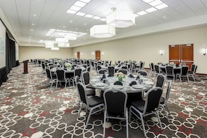 A conference room with round tables, black chairs, and a patterned carpet. - Four Points by Sheraton Bentonville (Bentonville)