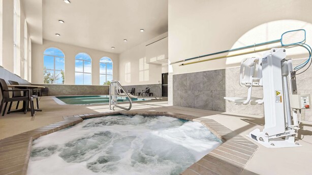 A spa area with a hot tub, seating area, and a view of the pool. - Comfort Inn & Suites Pueblo (Pueblo)