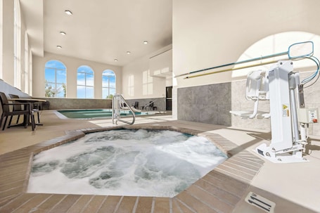 Una piscina techada, sillones reclinables de piscina