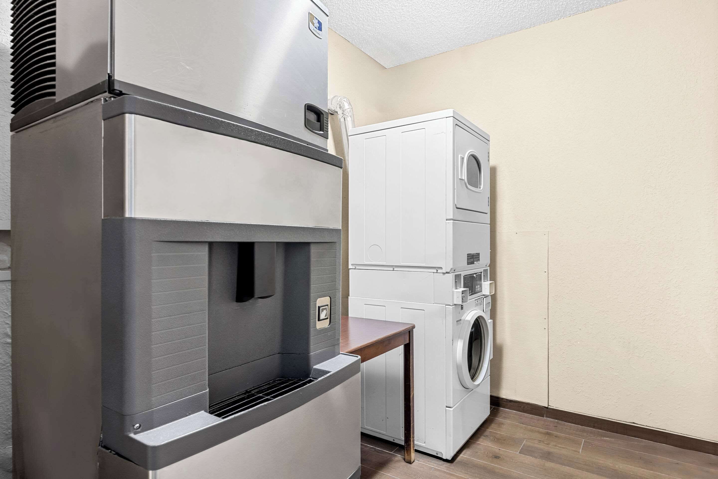 Una cocina compacta con refrigerador integrado, microondas y lavadora.