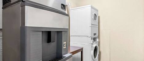 Una cocina compacta con refrigerador integrado, microondas y lavadora.