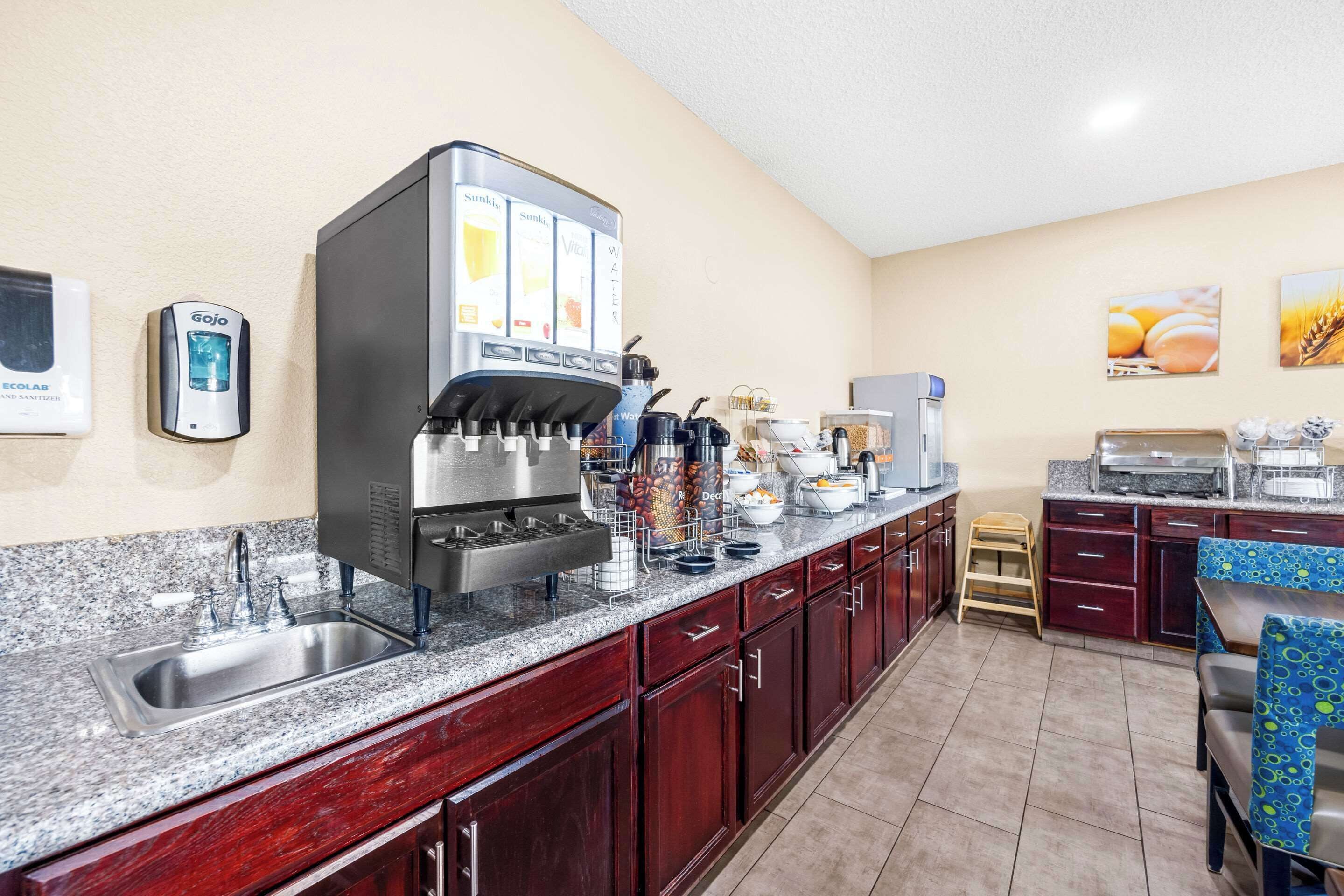 Een moderne keuken met een koffieapparaat, een spoelbak en een ontbijtbalk.