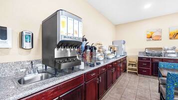 A modern kitchen with a coffee machine, a sink, and a breakfast bar.