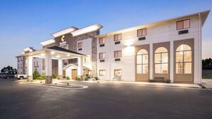 A hotel with a modern design, featuring a covered entrance, multiple windows, and a well-lit facade. - Comfort Inn & Suites Pueblo (Pueblo)