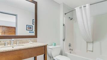 A bathroom with a sink, toilet, and bathtub.