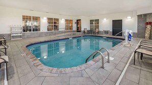 Une piscine dotée d’une plage carrelée, entourée de chaises et d’un vestiaire.