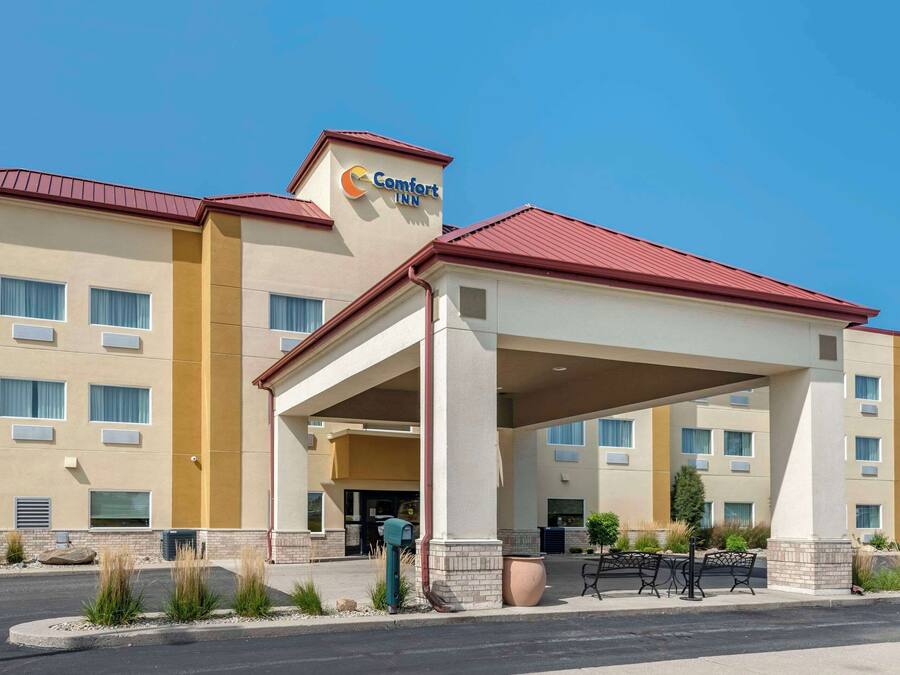 A Comfort Inn hotel with a covered entrance, multiple windows, and a red roof.