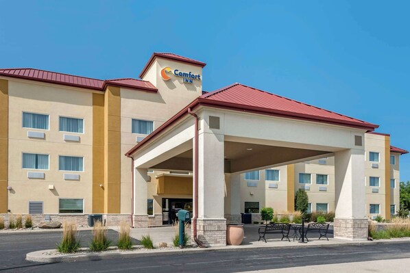 A Comfort Inn hotel with a covered entrance, multiple windows, and a red roof.