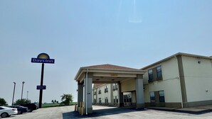 A Days Inn building with a covered outdoor area and an indoor pool sign. - Days Inn by Wyndham Walcott Davenport (Walcott)