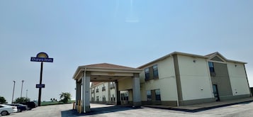 Edificio de Days Inn con un área exterior cubierta y un letrero que indica una piscina interior.