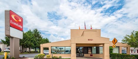 Un hotel llamado Econolodge con fachada color beige, un letrero grande y una señal de paso de peatones.