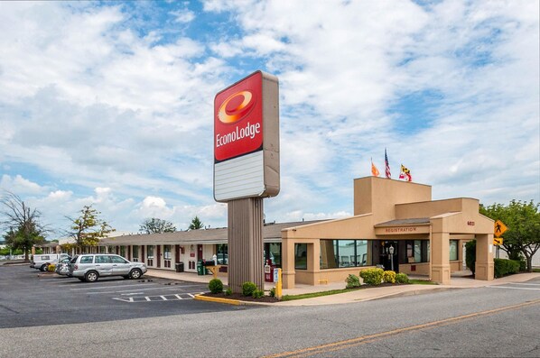 A hotel with a prominent EconoLodge sign, a registration desk, and a parking lot with several cars.