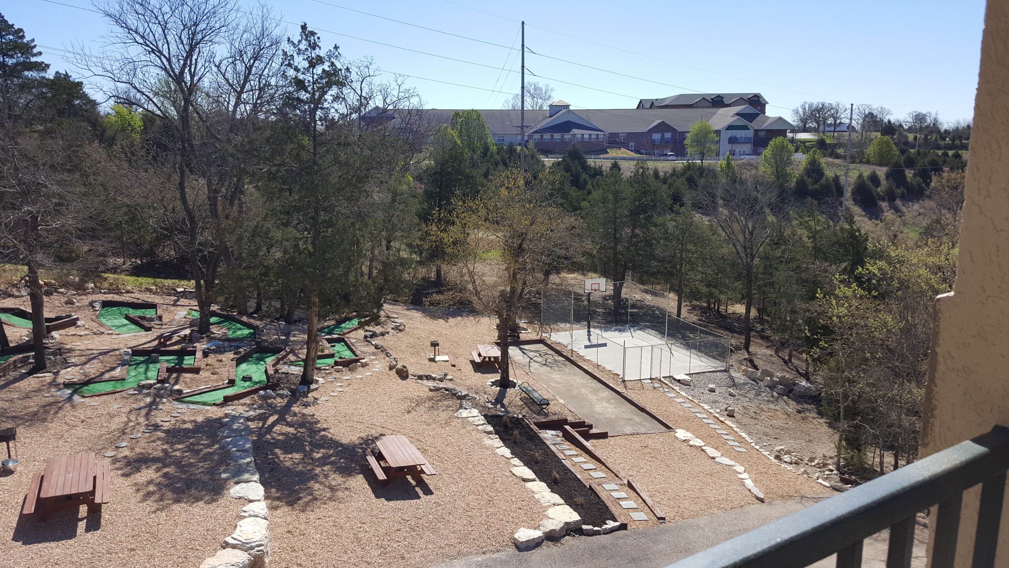 Une vue d’un terrain de golf avec de nombreux espaces verts et un bâtiment en arrière-plan.