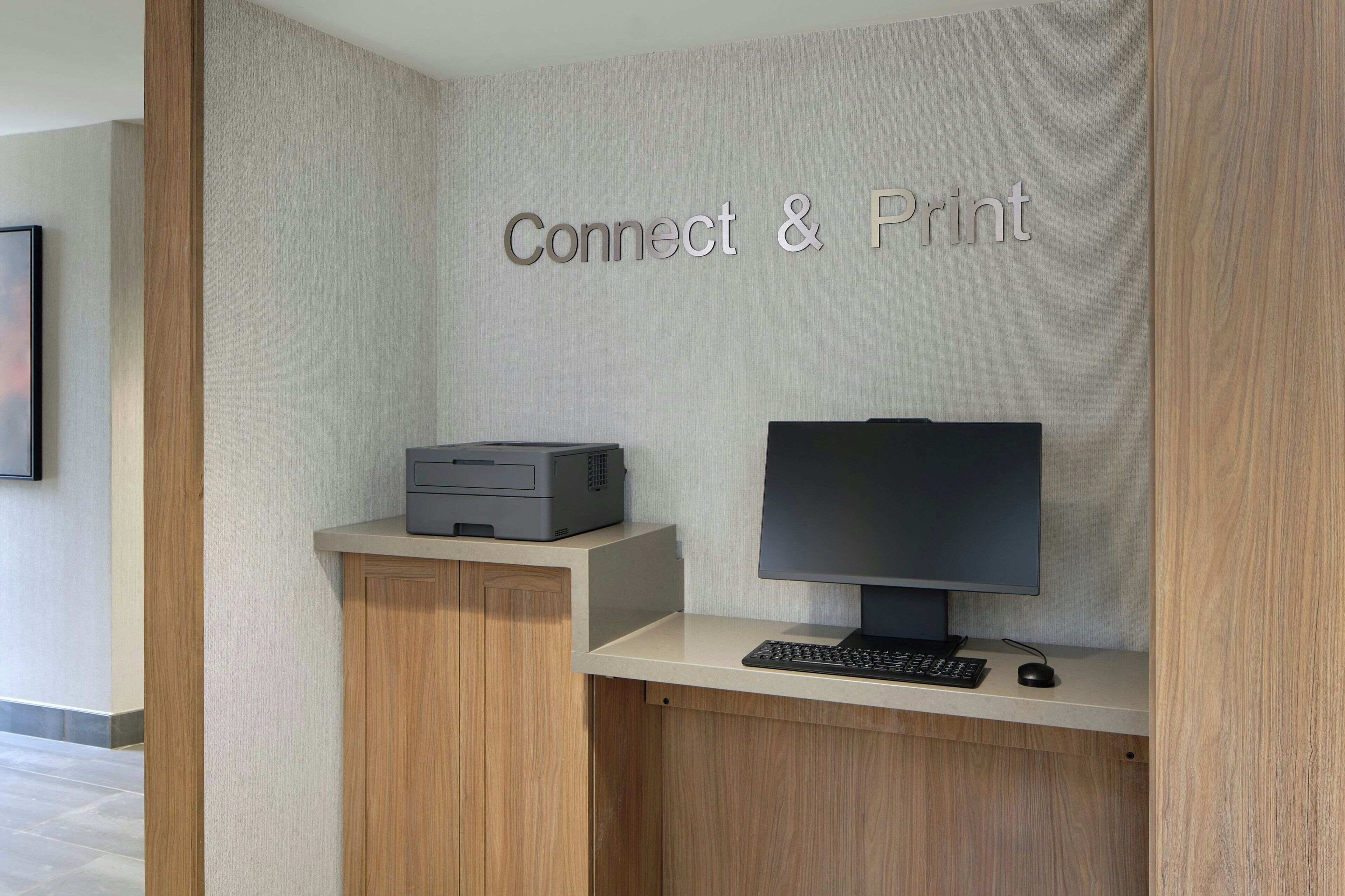 A workspace with a computer, monitor, and printer labeled "Connect & Print".