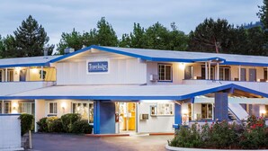 A Travelodge hotel with a two-story structure, a covered outdoor area, and a well-lit entrance.