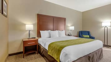 A hotel room with a large bed, two bedside tables, a chair, and a floor lamp.
