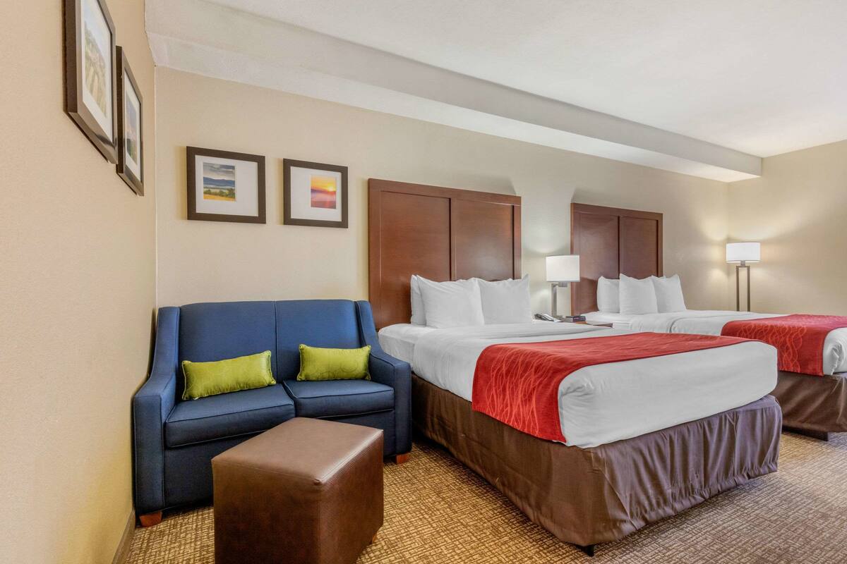 Une chambre d’hôtel avec un lit, un canapé et une petite table.