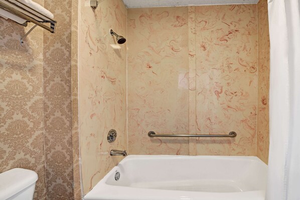 Un baño con bañera, ducha e inodoro.