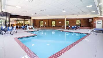 Relax by the rectangular pool surrounded by lounge chairs and umbrellas.