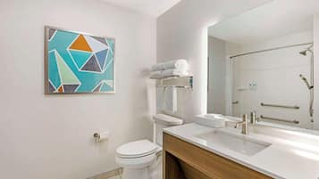 A modern bathroom with a white toilet, a sink with a mirror, and a towel rack.