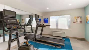 Ein Fitnessraum mit Laufbändern, einem Ergometer und einem Rudergerät.