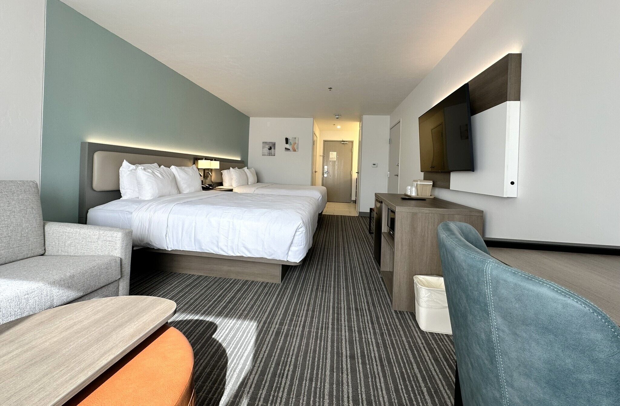 Una habitación de hotel con cama, escritorio, silla y televisor.