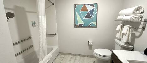 A modern bathroom with a shower, toilet, and sink.