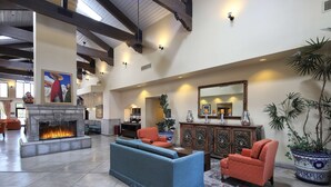 A spacious lobby with a fireplace, seating area, and a large mirror. - Hampton Inn & Suites Tucson-Mall (Tucson)