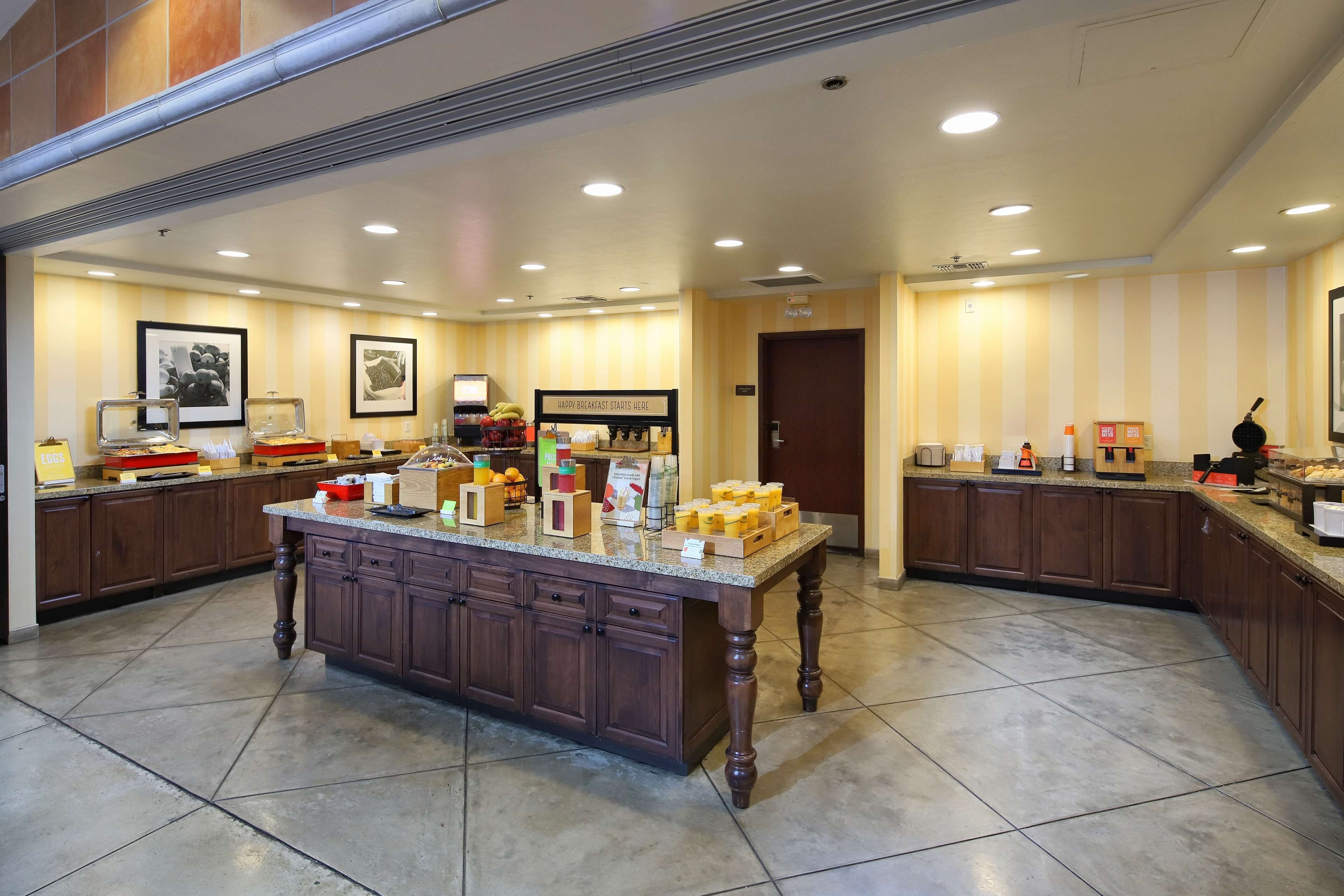 Una amplia cocina de hotel con una isla central, equipada con diversos alimentos y electrodomésticos.