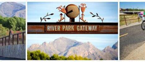 A sign with 'River Park Gateway' and a mountainous landscape in the background.