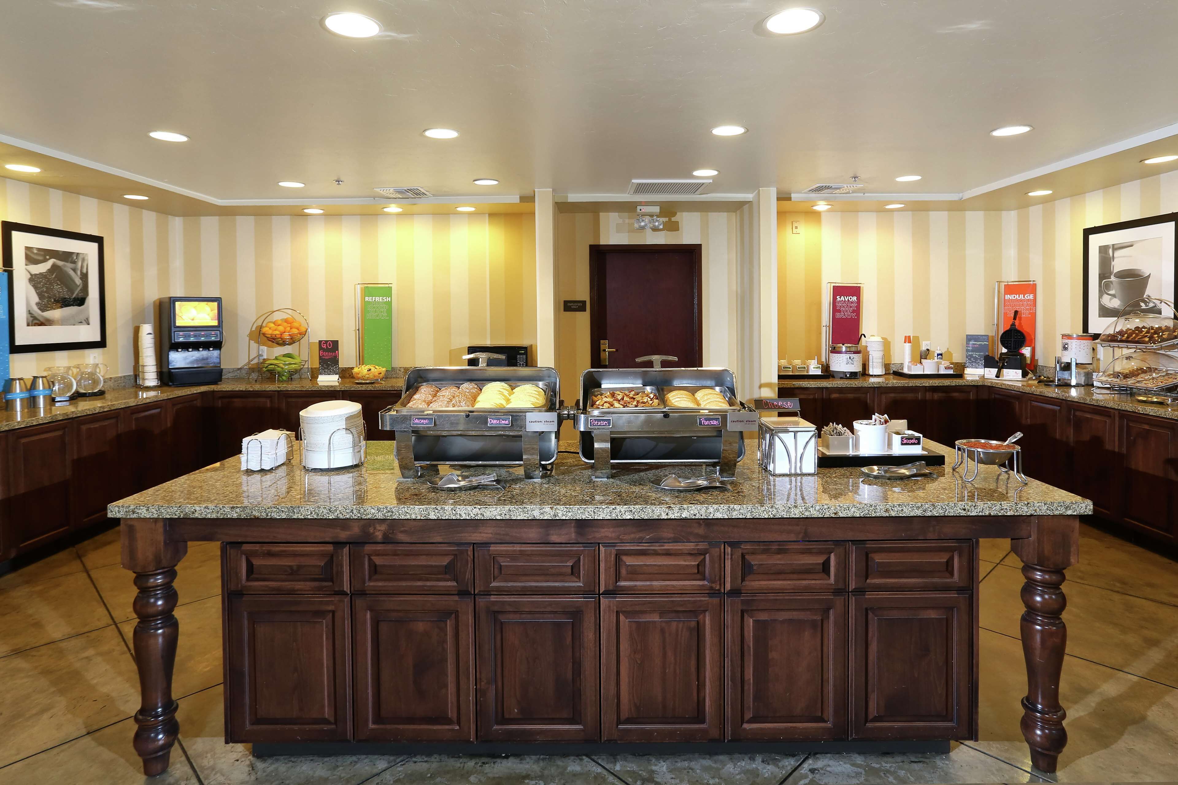 A buffet counter with various food items and a coffee station.