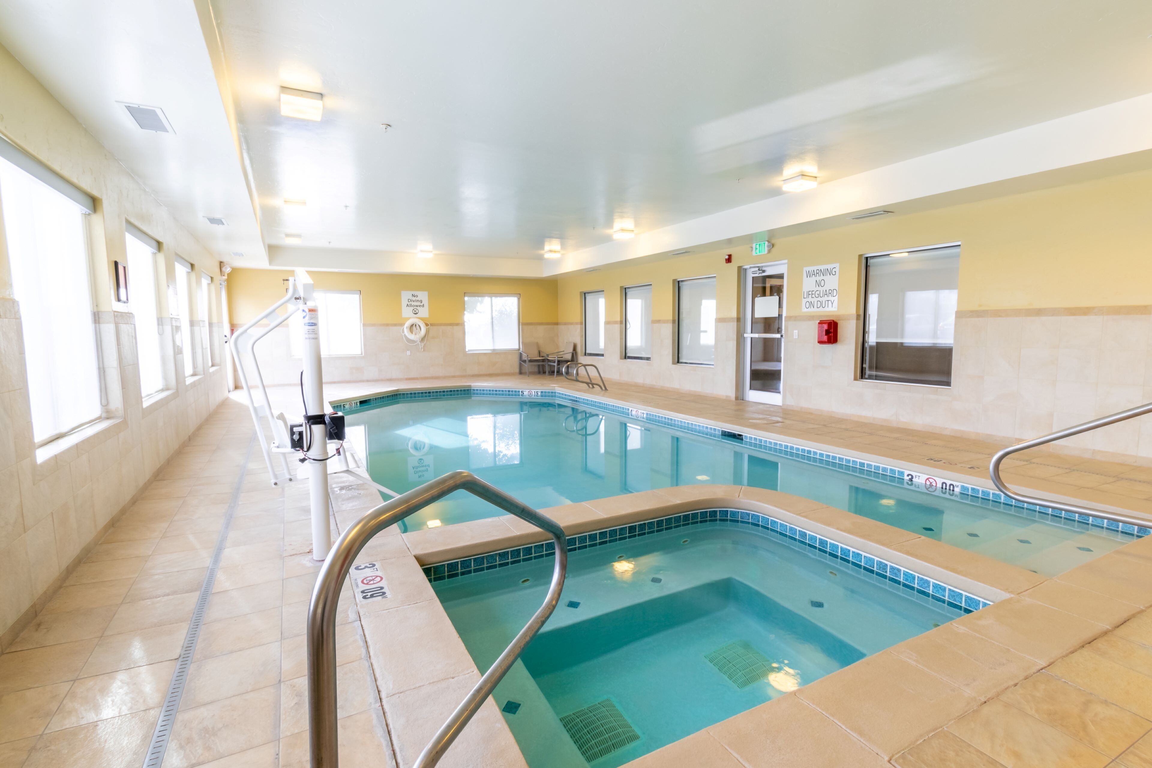 An indoor swimming pool with clear water, tiled walls, and a no diving allowed sign.